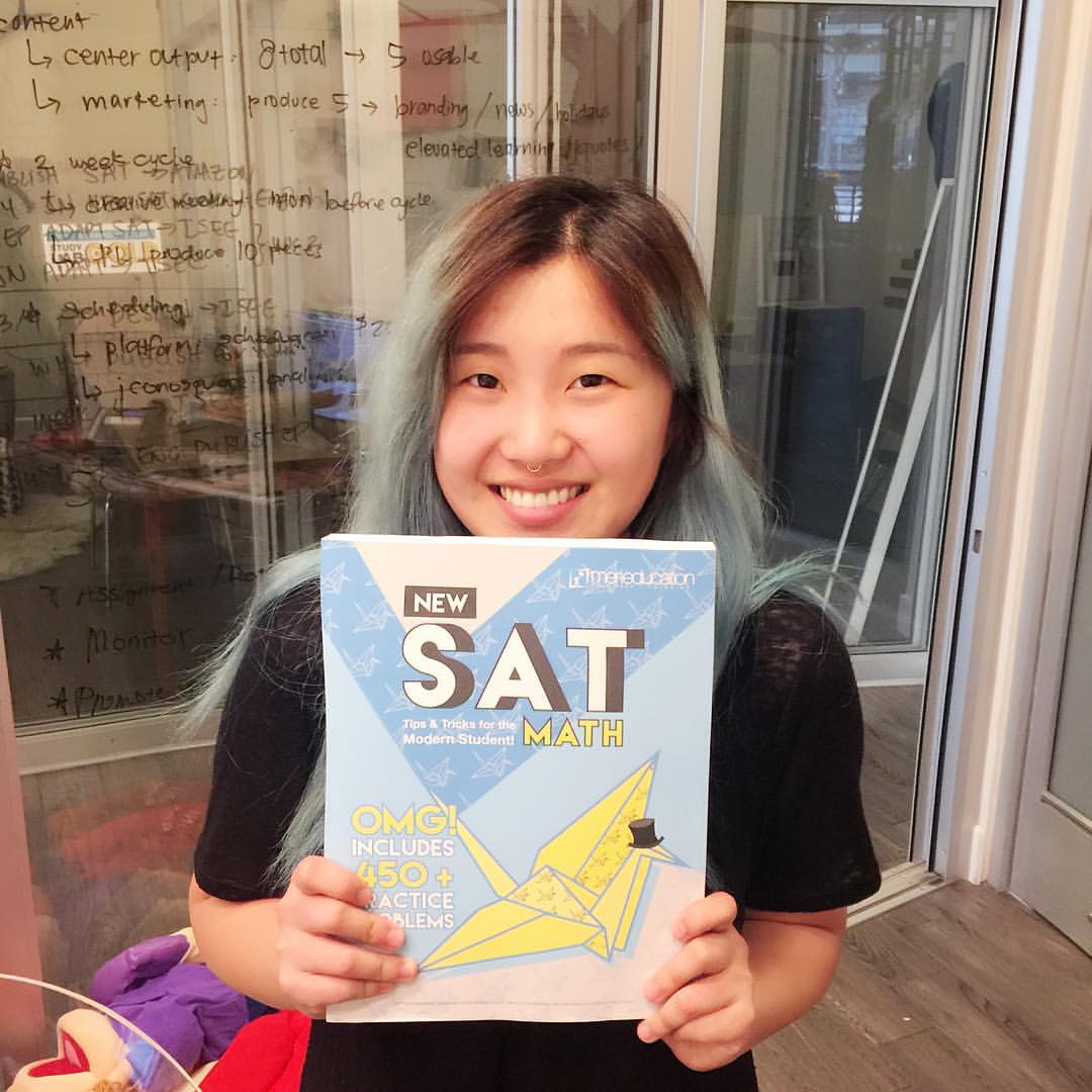 a girl holds SAT math book