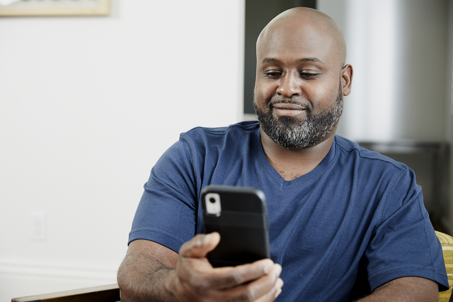 smiling-man-looking-at-smartphone