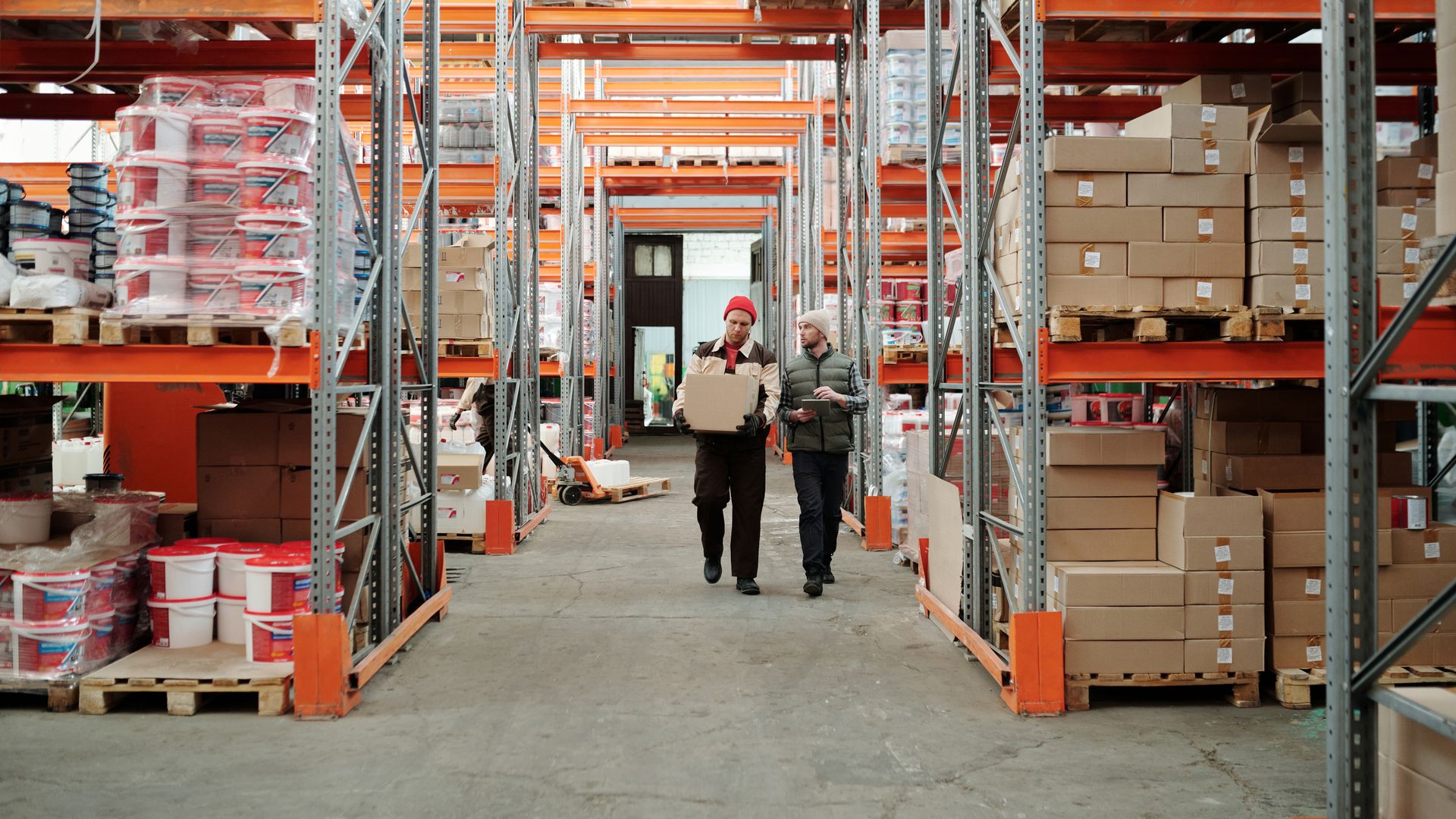 Workers moving pallets down an aisle in an ecommerce fulfillment warehouse
