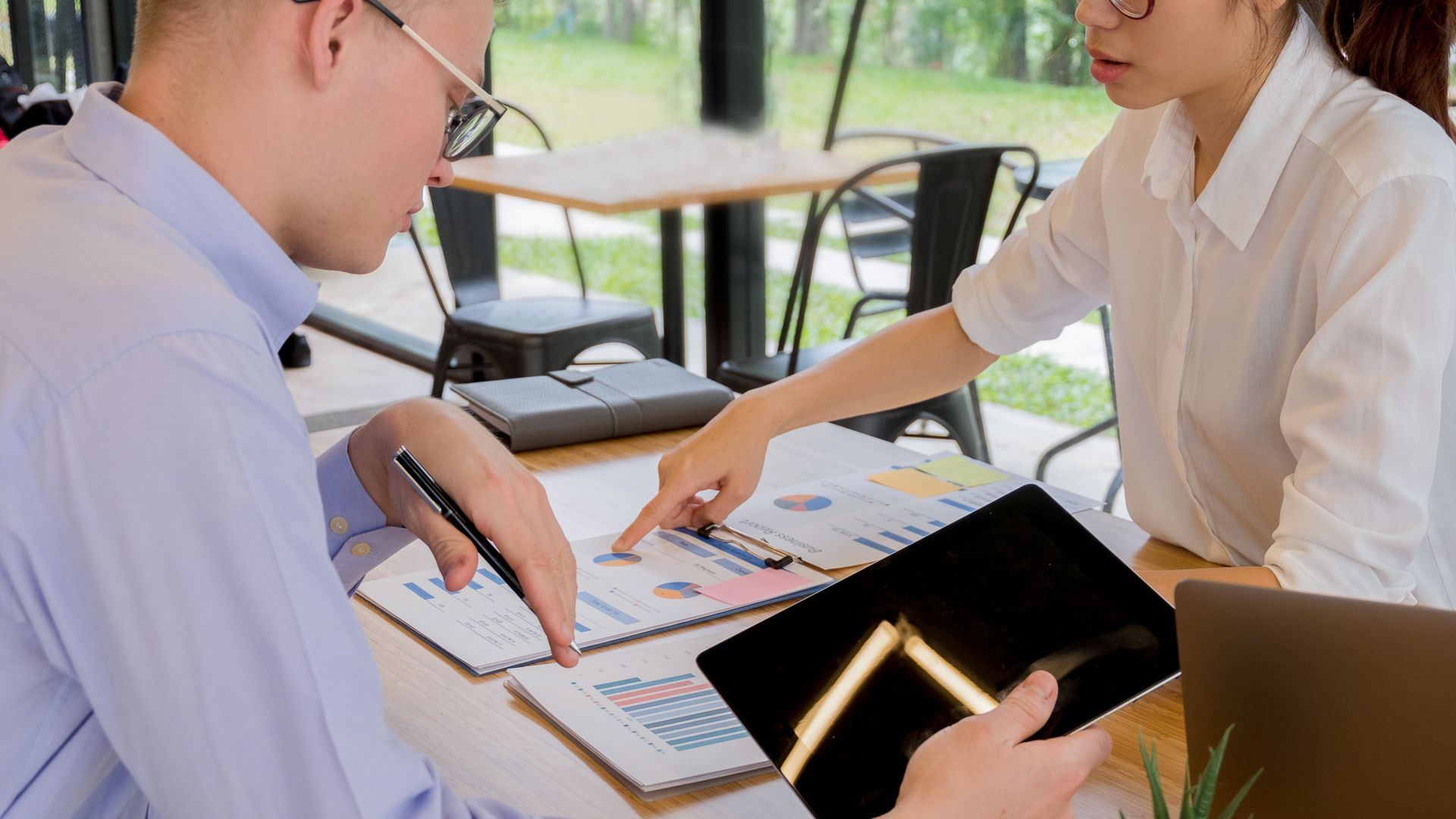 Marketing and operations teams collaborating over documents in a meeting to align on order fulfillment