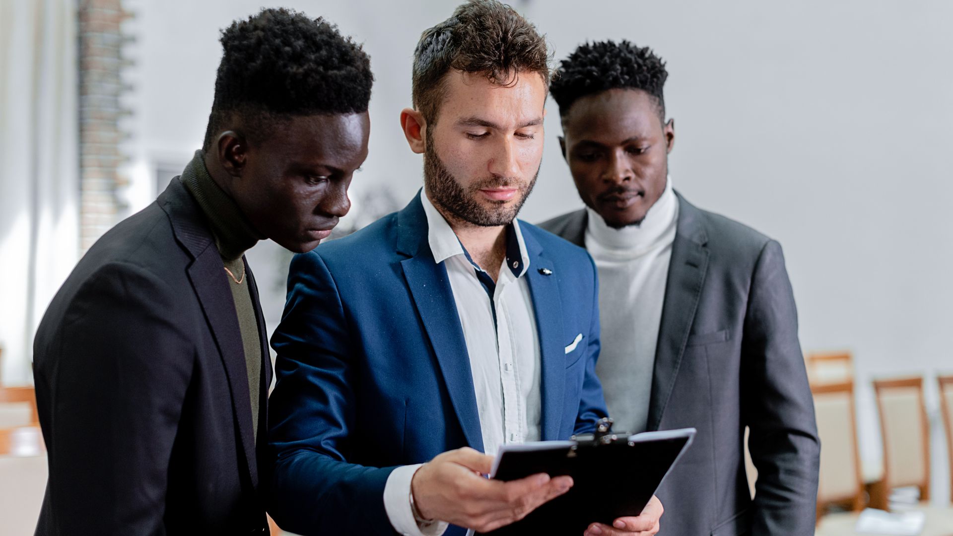Three business people reviewing a fulfillment contract document together during a 3PL evaluation meeting