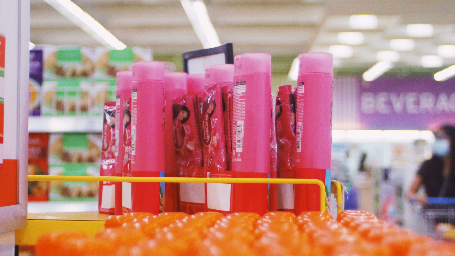 Rows of colorful hair care and shampoo bottles lined up on retail shelving