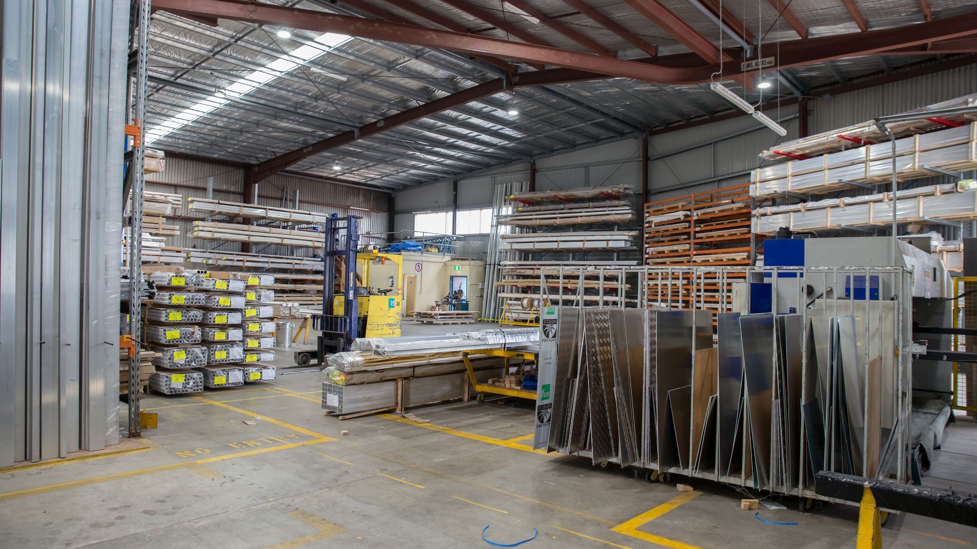 Spacious industrial warehouse interior with tall pallet racking and storage racks