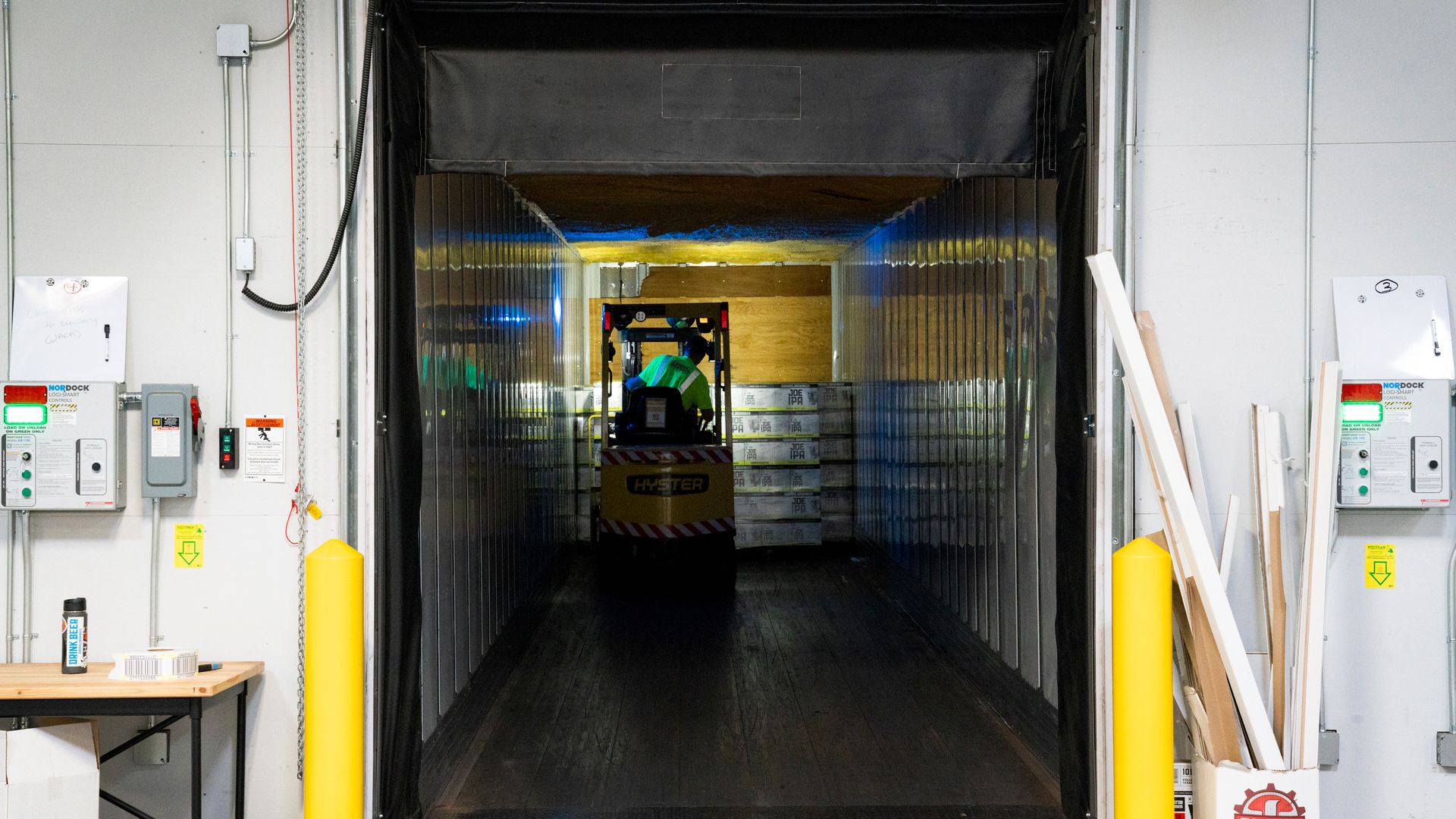 A forklift unloading goods at an industrial loading dock inside a warehouse