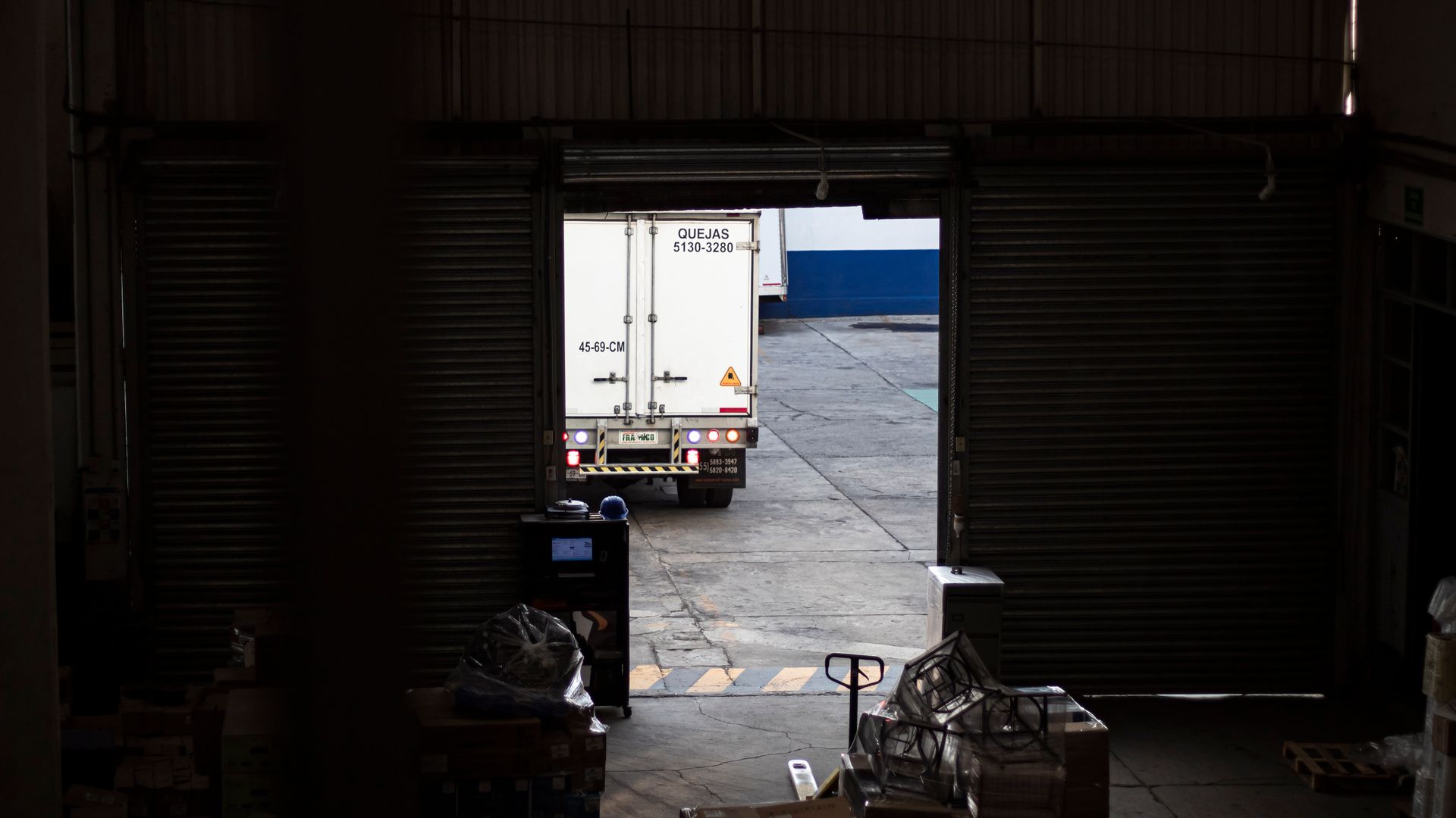 Delivery truck pulling away from a warehouse loading dock