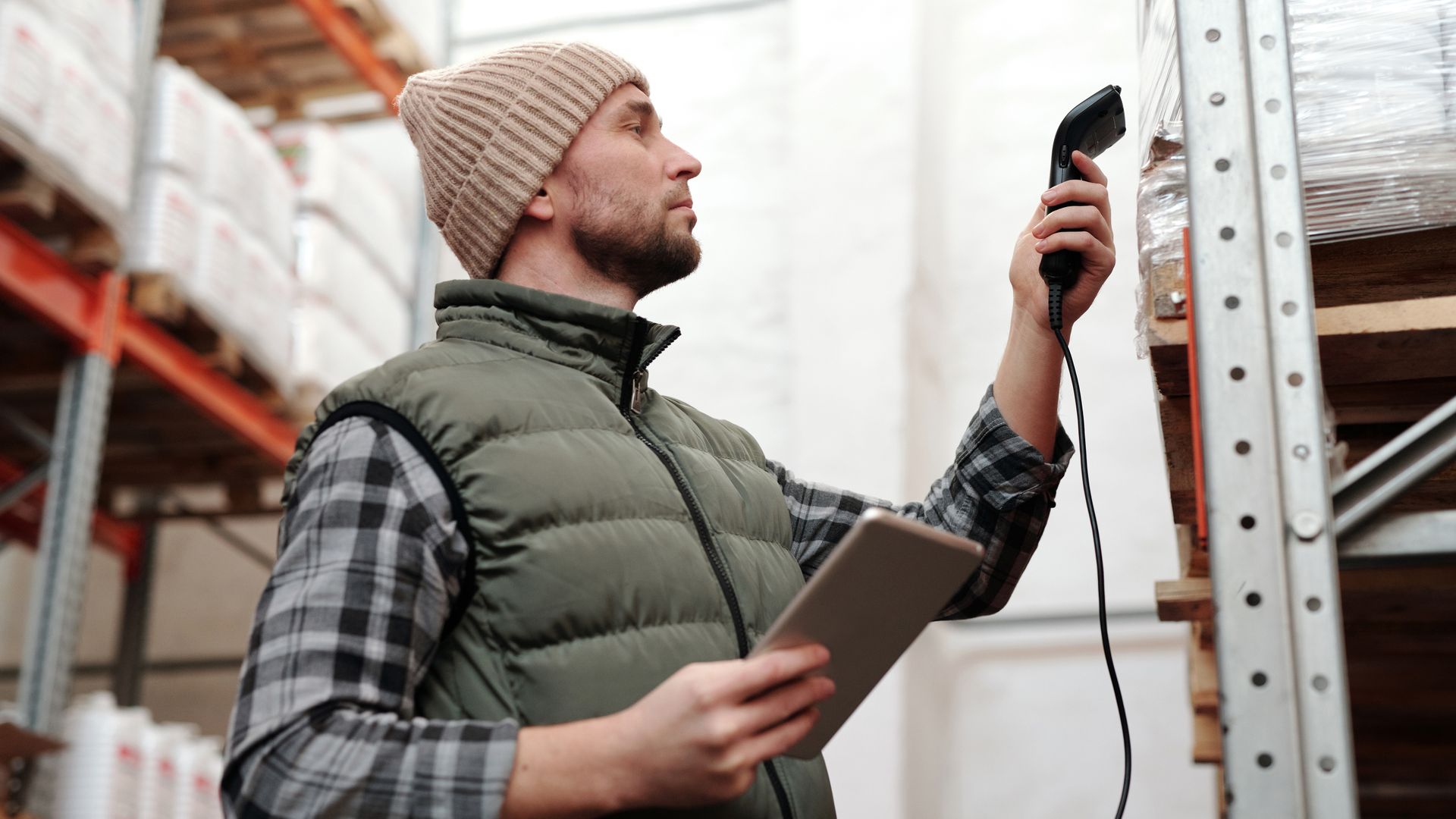 Warehouse worker scanning product barcodes with a handheld scanner