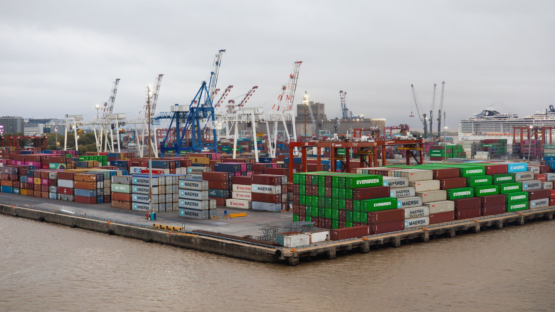 Stacked cargo containers and cranes at a shipping port