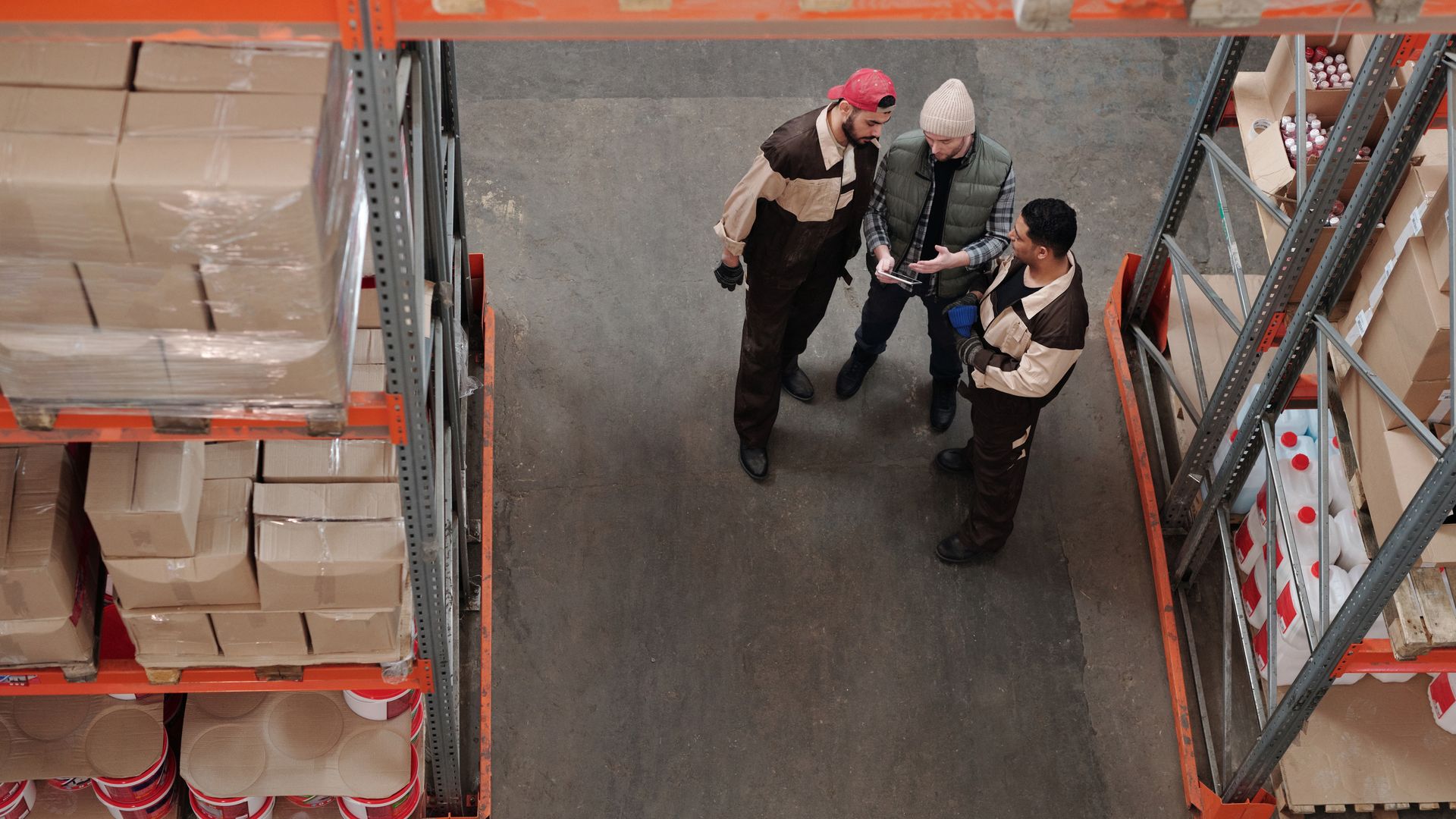 Two warehouse team members talking in a fulfillment center aisle