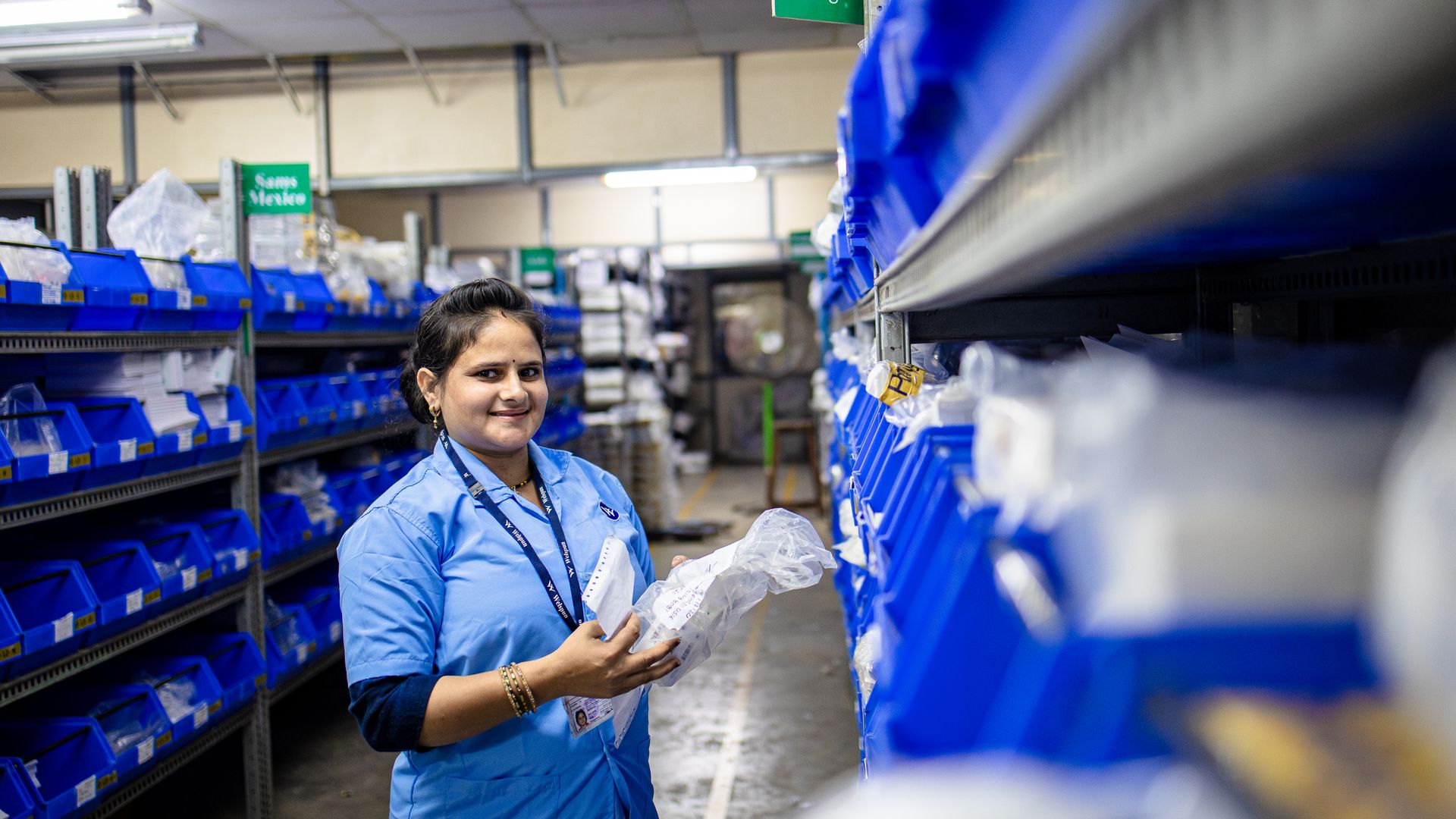 Woman organizing boxed inventory on warehouse shelves