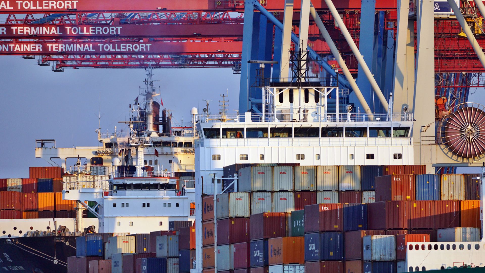 Container ships docked at a port terminal at sunset