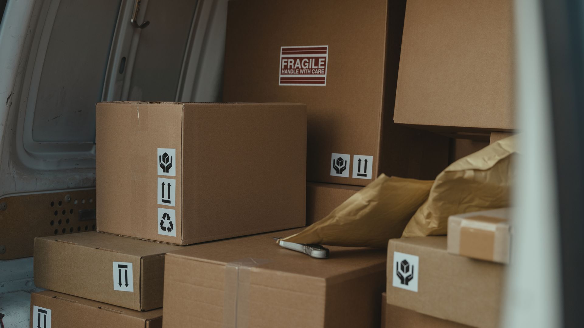 Cardboard boxes stacked neatly inside a delivery van ready for shipment