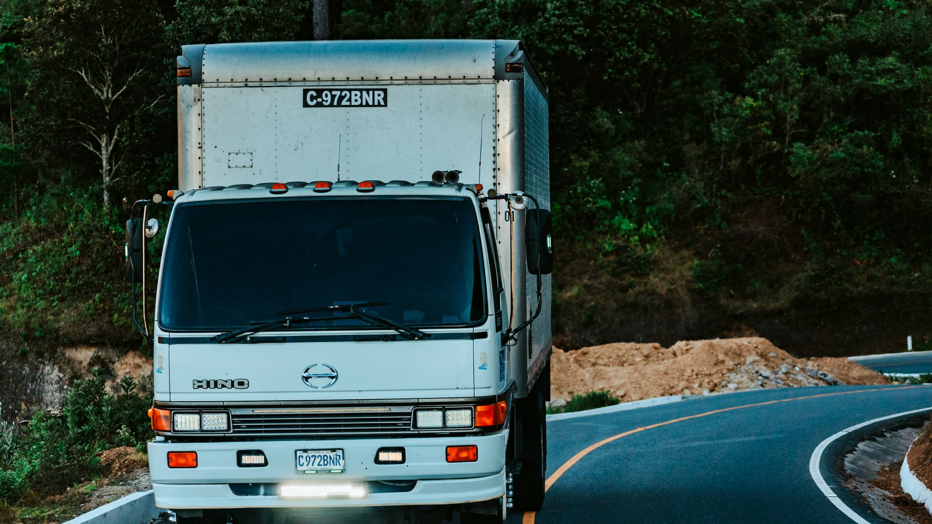 White box truck driving on a curving highway
