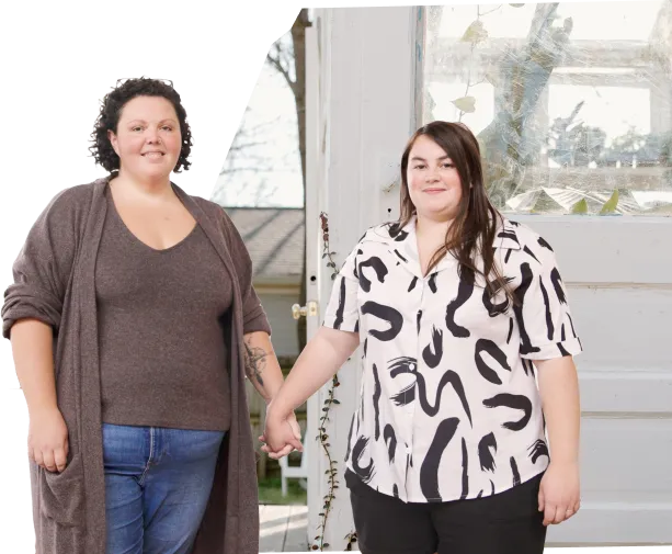 two women standing hand in hand with each other