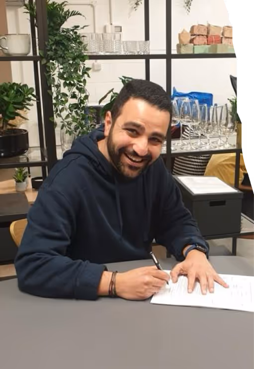 A man holding a pen, signing a document