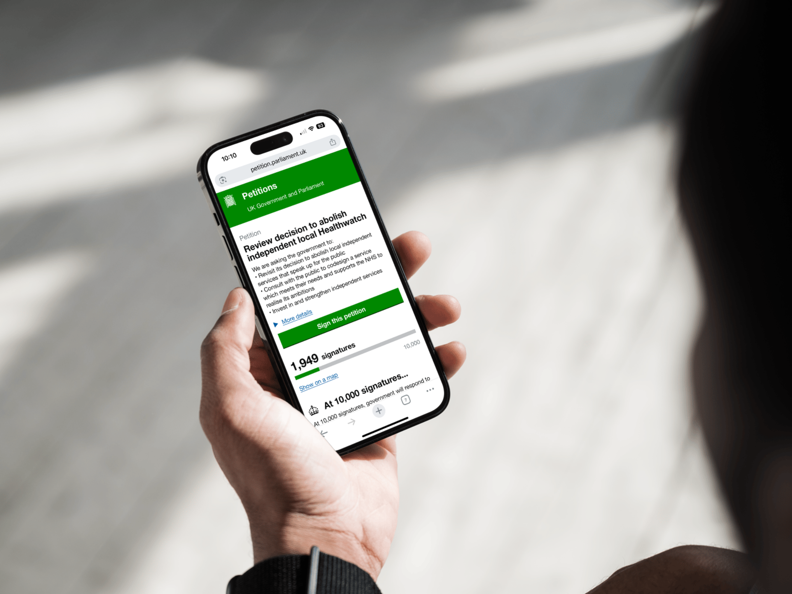 Person holding smarphone looking at a UK government petition. 