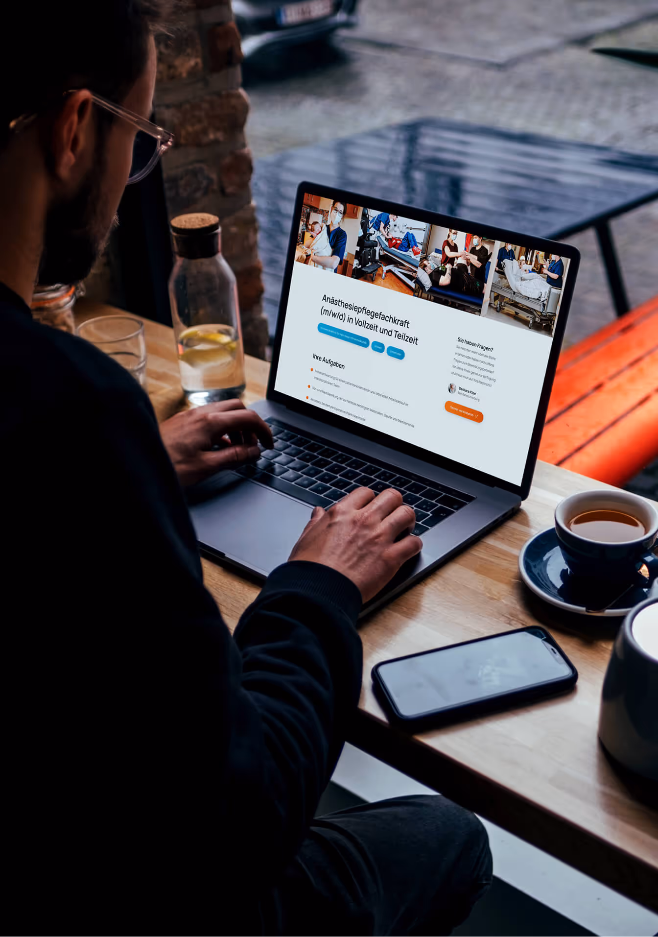 Mann sitzt mit einem Macbook in einem Cafe und hat die EV-Website im Browser geöffnet
