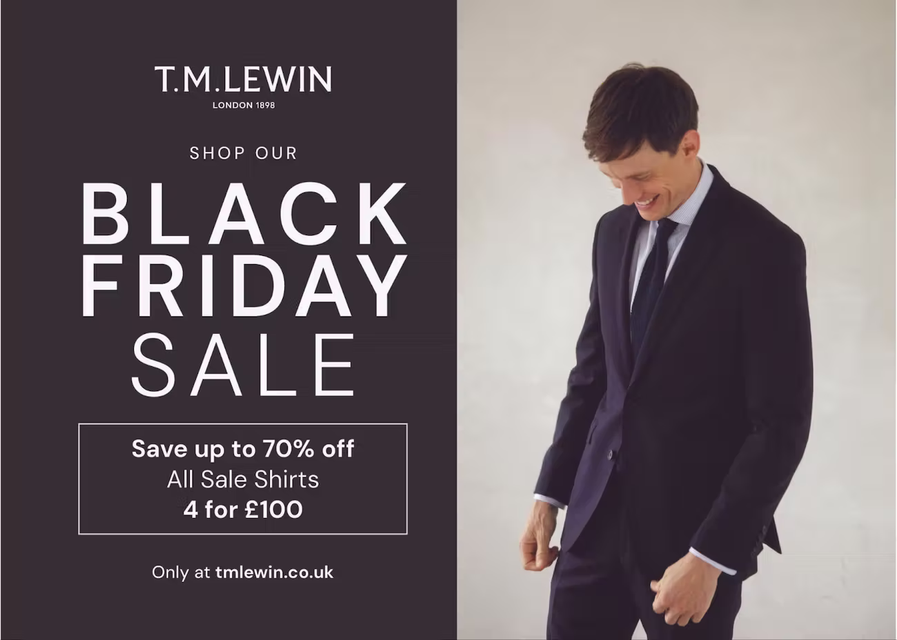 A minimalist split-design postcard from T.M. Lewin. On the left side, bold white text over a dark charcoal background announces: “Shop our Black Friday Sale – Save up to 70% off. All sale shirts 4 for £100.” The right side features a well-dressed man in a navy suit and tie, smiling while looking down. Footer text: “Only at tmlewin.co.uk.”