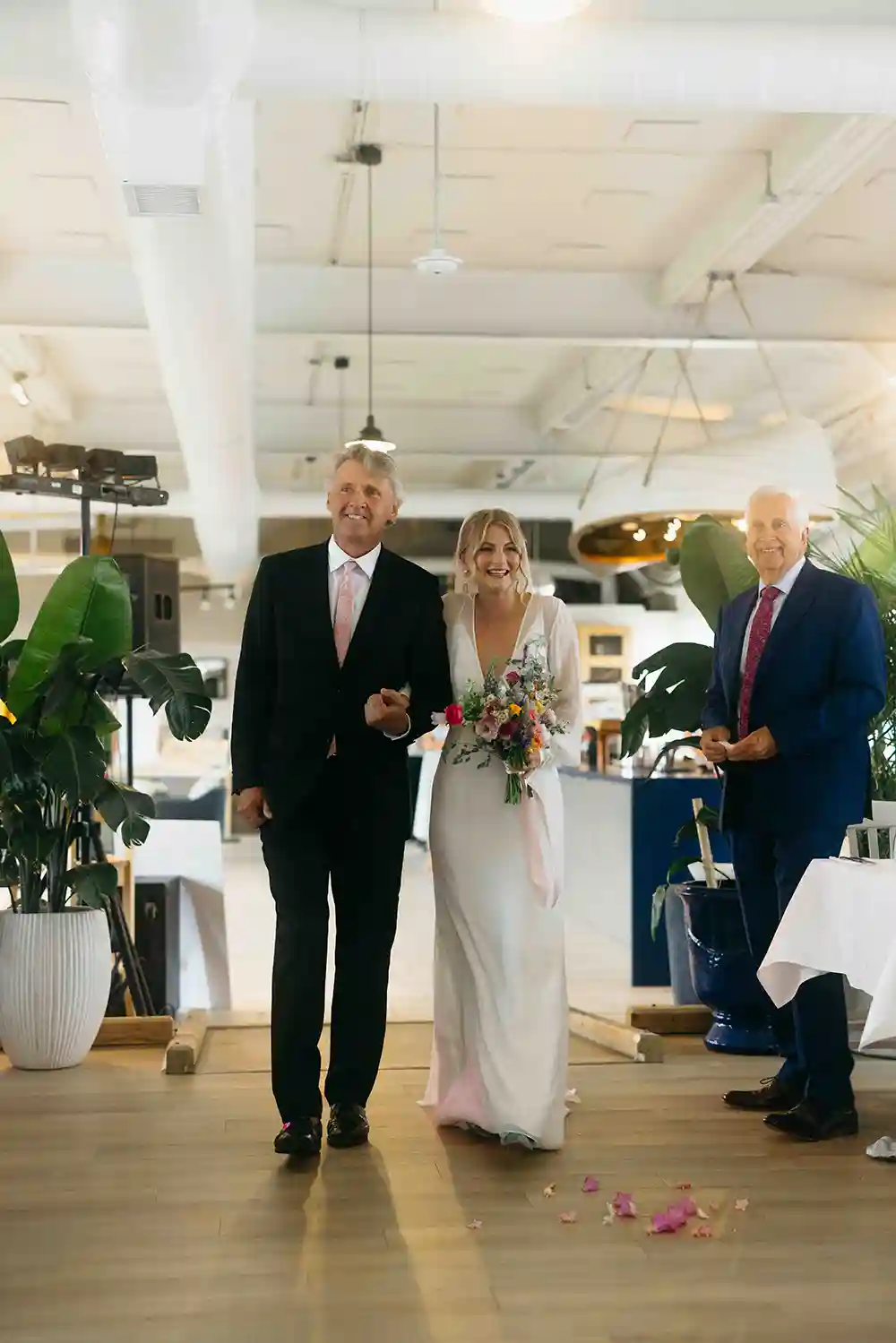 The father of the bride walks the bride into Cable Wharf Restaurant.