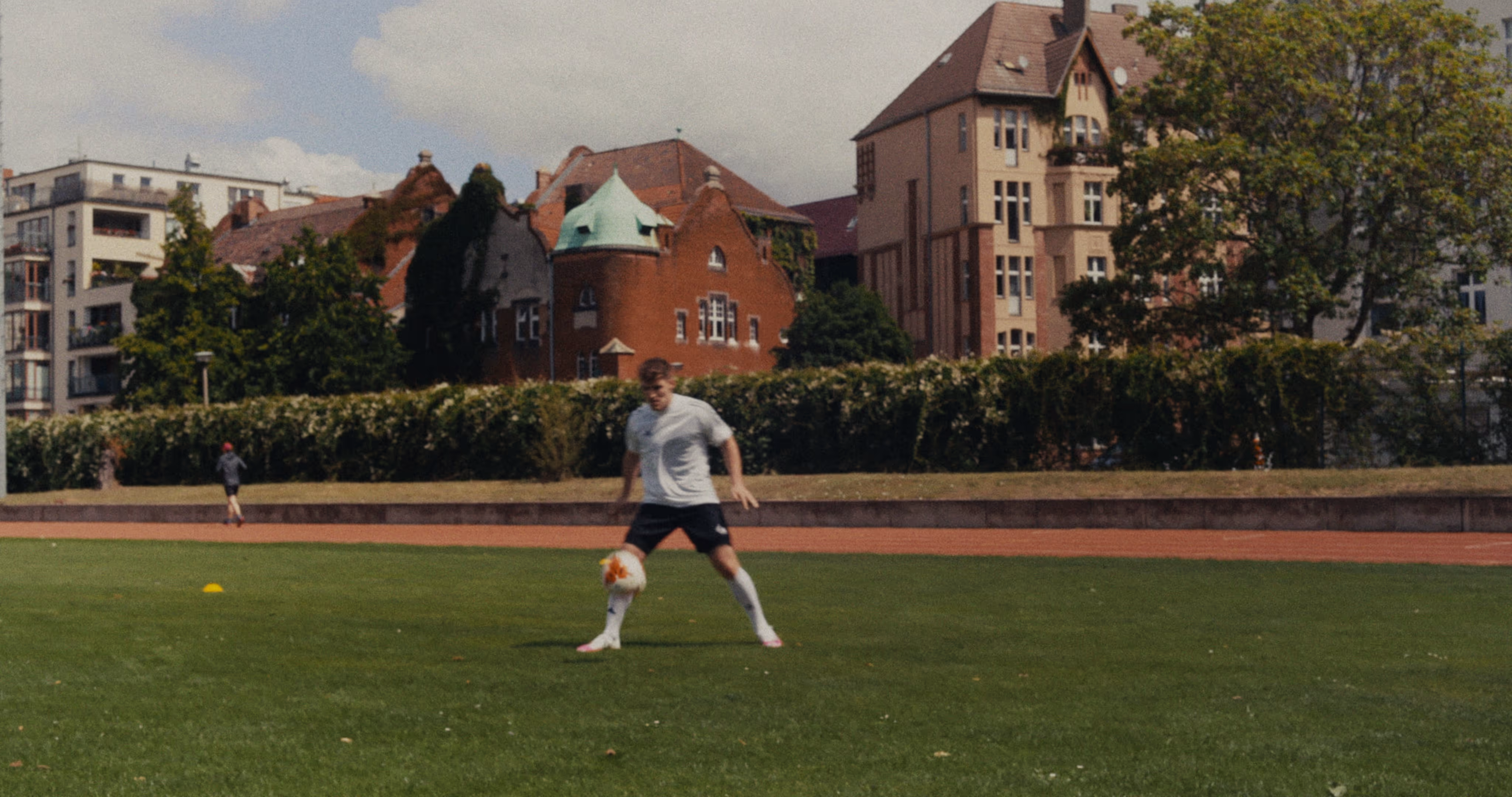 A football player stops the ball on a football pitch.
