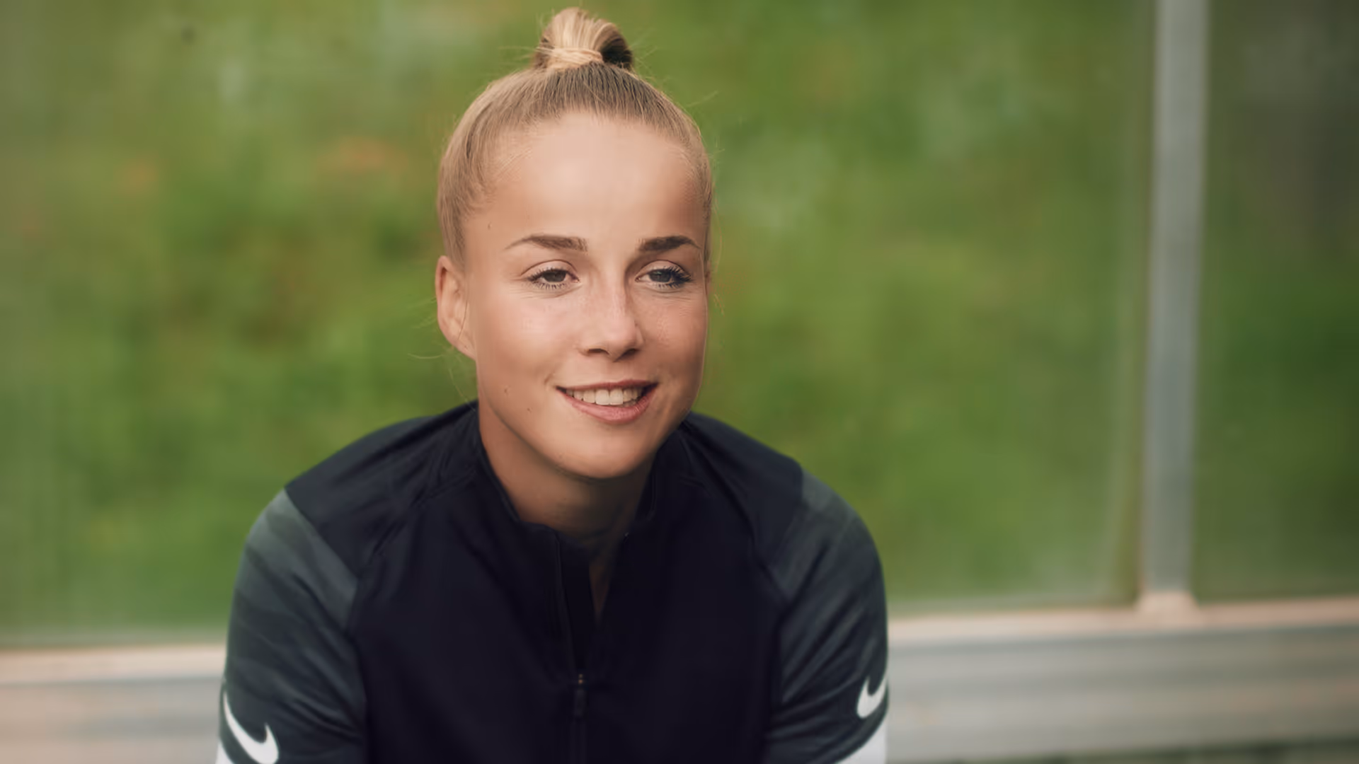 Giulia Gwinn sits on a bench and gives an interview.