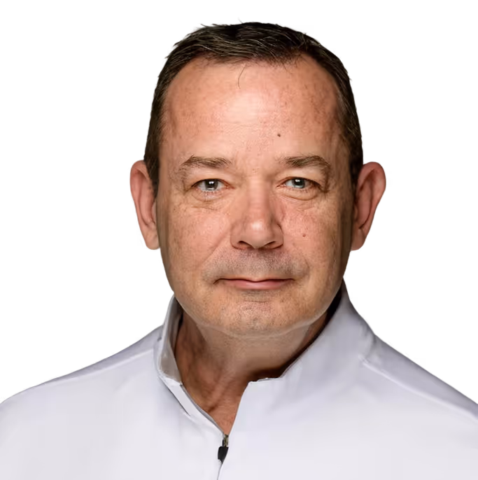 Portrait of a middle-aged man with short dark hair wearing a white zip-collar shirt against a transparent background.