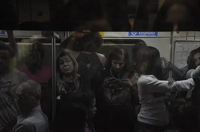 Vagão de metrô lotado com pessoas em silêncio e semblante cansado