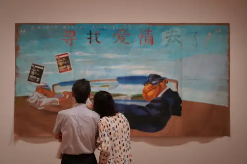 Casal apreciando juntos uma obra de arte em uma galeria, observando atentamente uma pintura com tons quentes e elementos modernos.