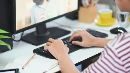 Pessoa digitando em computador de mesa durante atividade online de estudo ou trabalho