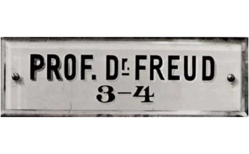 Placa antiga com o nome Prof. Dr. Freud exibida na porta de seu consultório em Viena