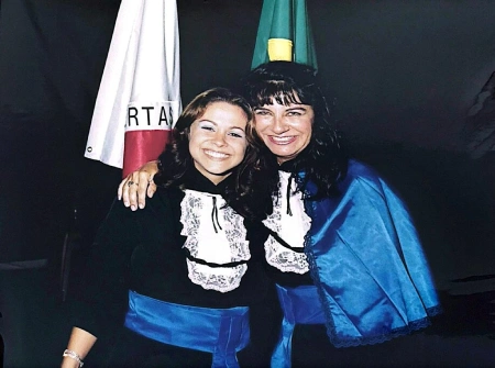 Fernanda Samico abraçada a professora Denise Maurano em evento de formatura, ambas de beca