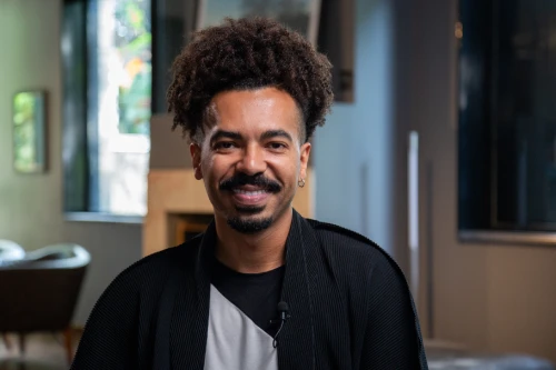 Retrato de Lucas Veiga com camisa preta em fundo neutro