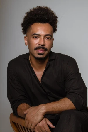 Lucas Veiga sentado em ambiente interno com expressão sorridente