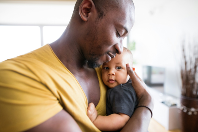 Homem abraçando um bebê no colo
