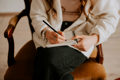 Psicóloga fazendo anotações em um caderno durante atendimento