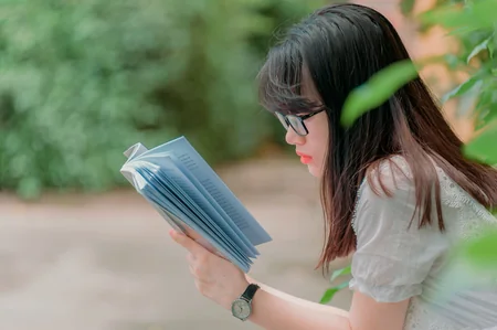 Mulher sentada ao ar livre lendo um livro