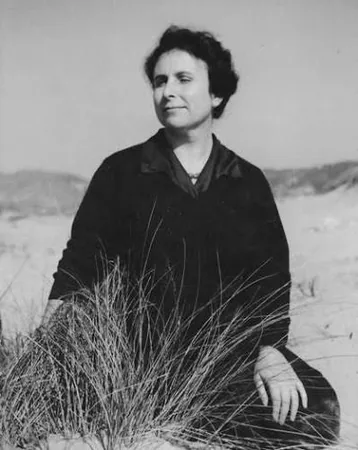 Agustina Bessa-Luís sentada entre a vegetação de uma praia