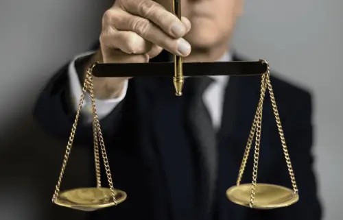 Pessoa segurando uma balança dourada da Justiça