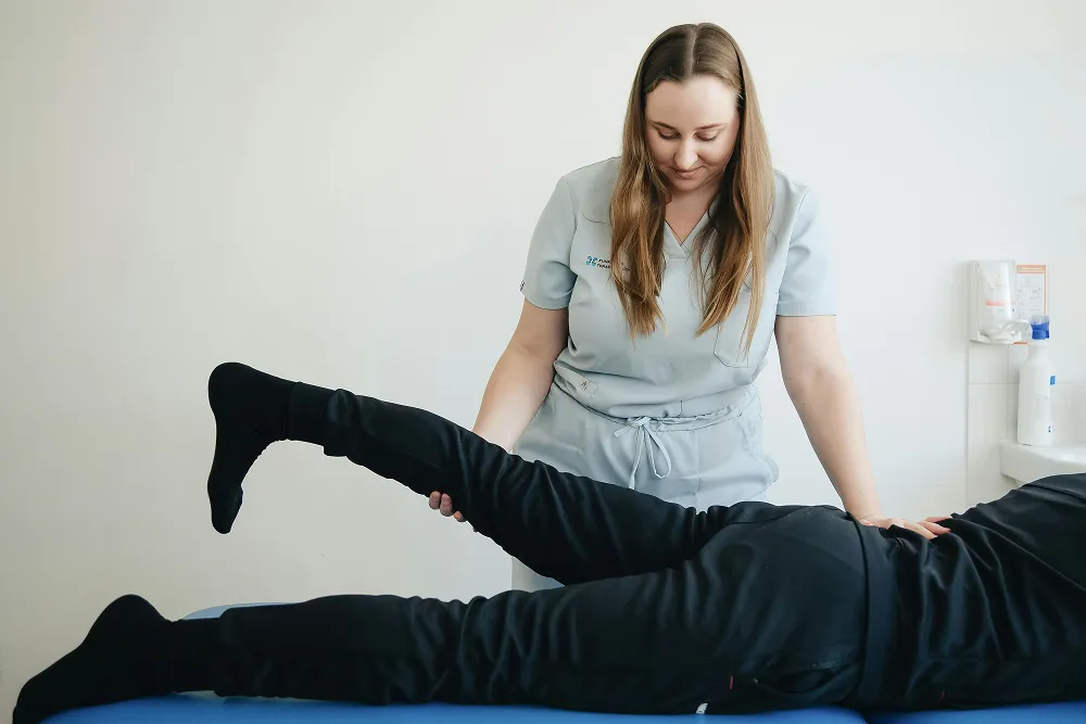 Chiropractor making adjustment on the leg of a patient