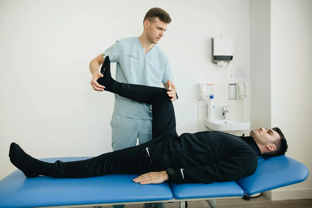 Chiropractor making a manouver on the leg of a man