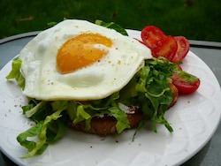 Open faced egg sandwhich with arugula salad
