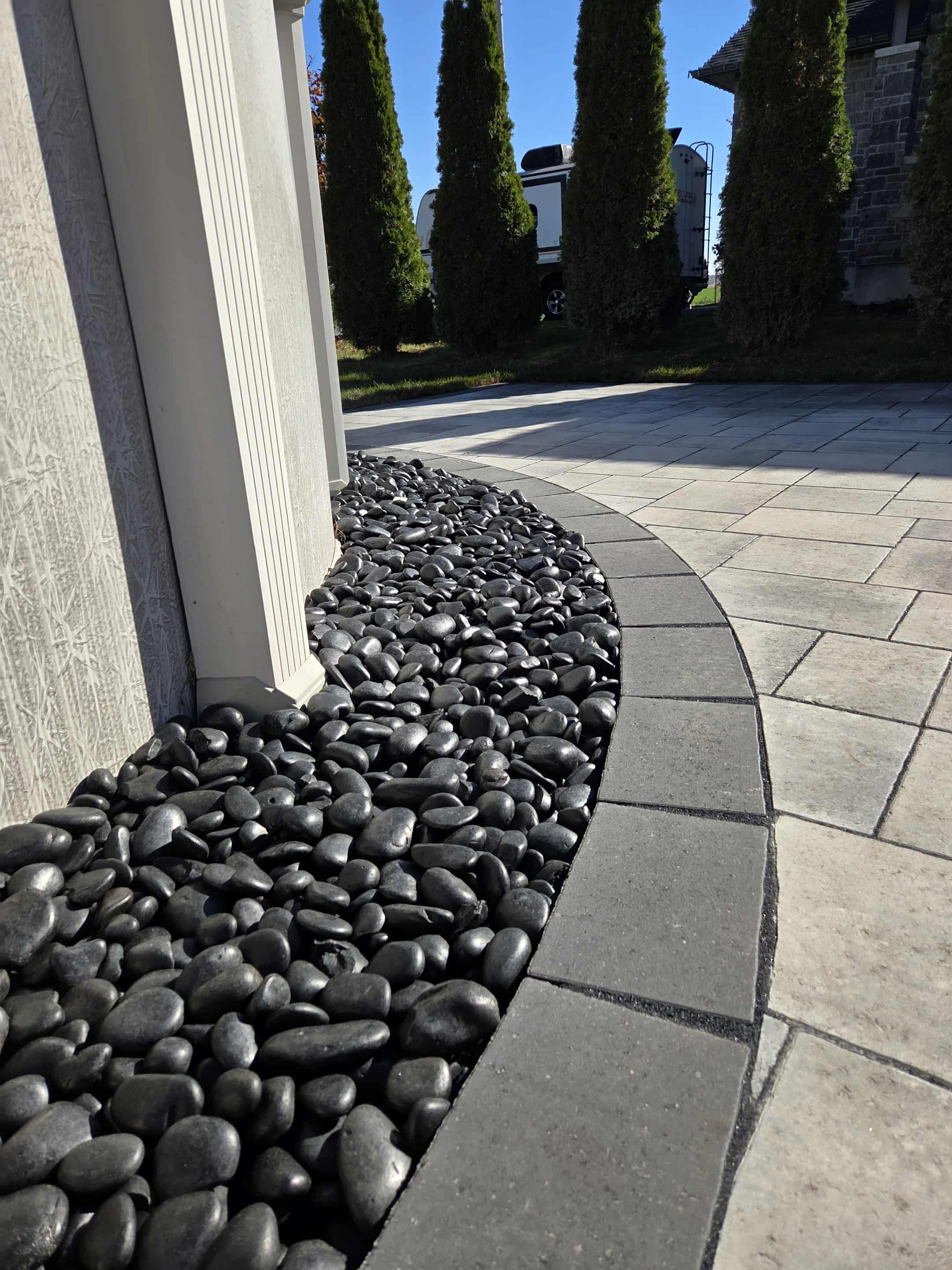 Black stones surrounding above ground pool