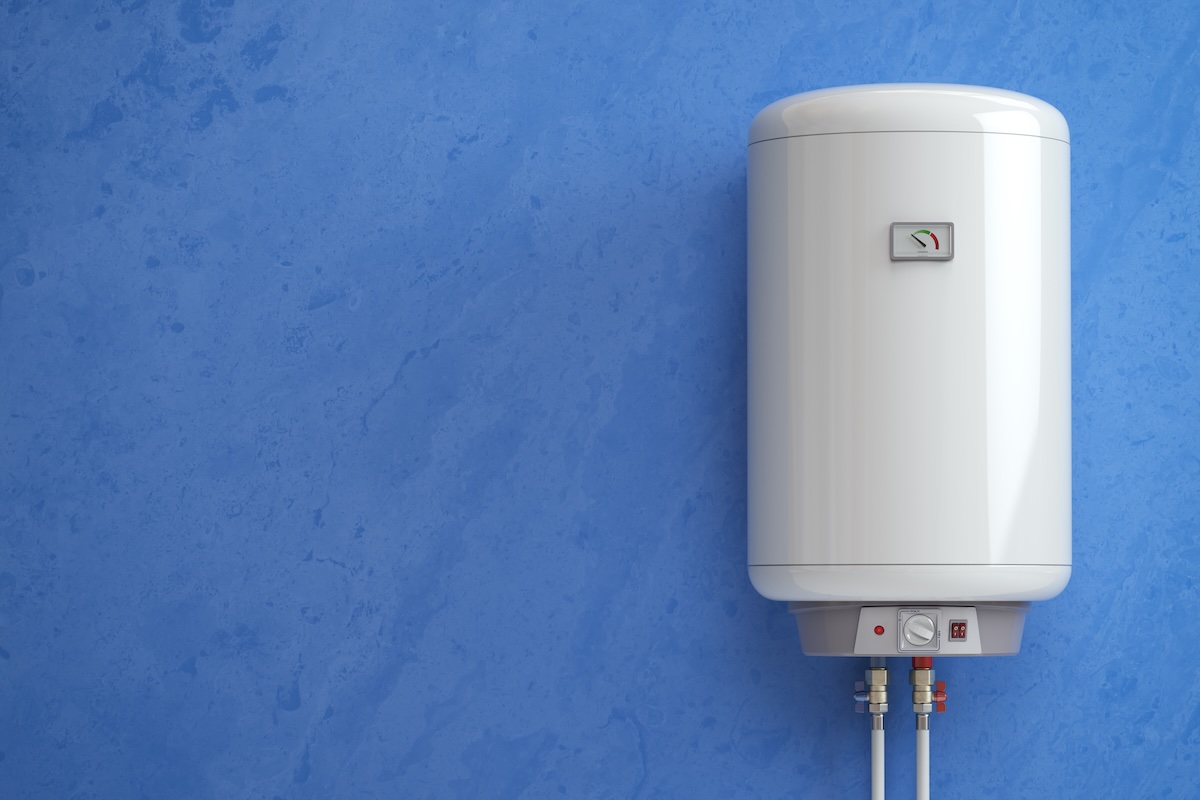 Wall-mounted white water heater with a temperature gauge installed against a blue wall