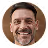Smiling man with short dark hair and beard wearing a white collared shirt.