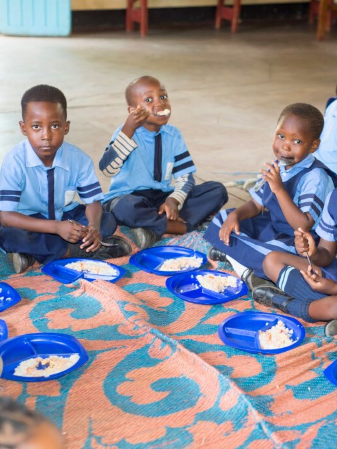 Schulkinder essen eine warme Mahlzeit in der Maria Regina Schule in Sambia.