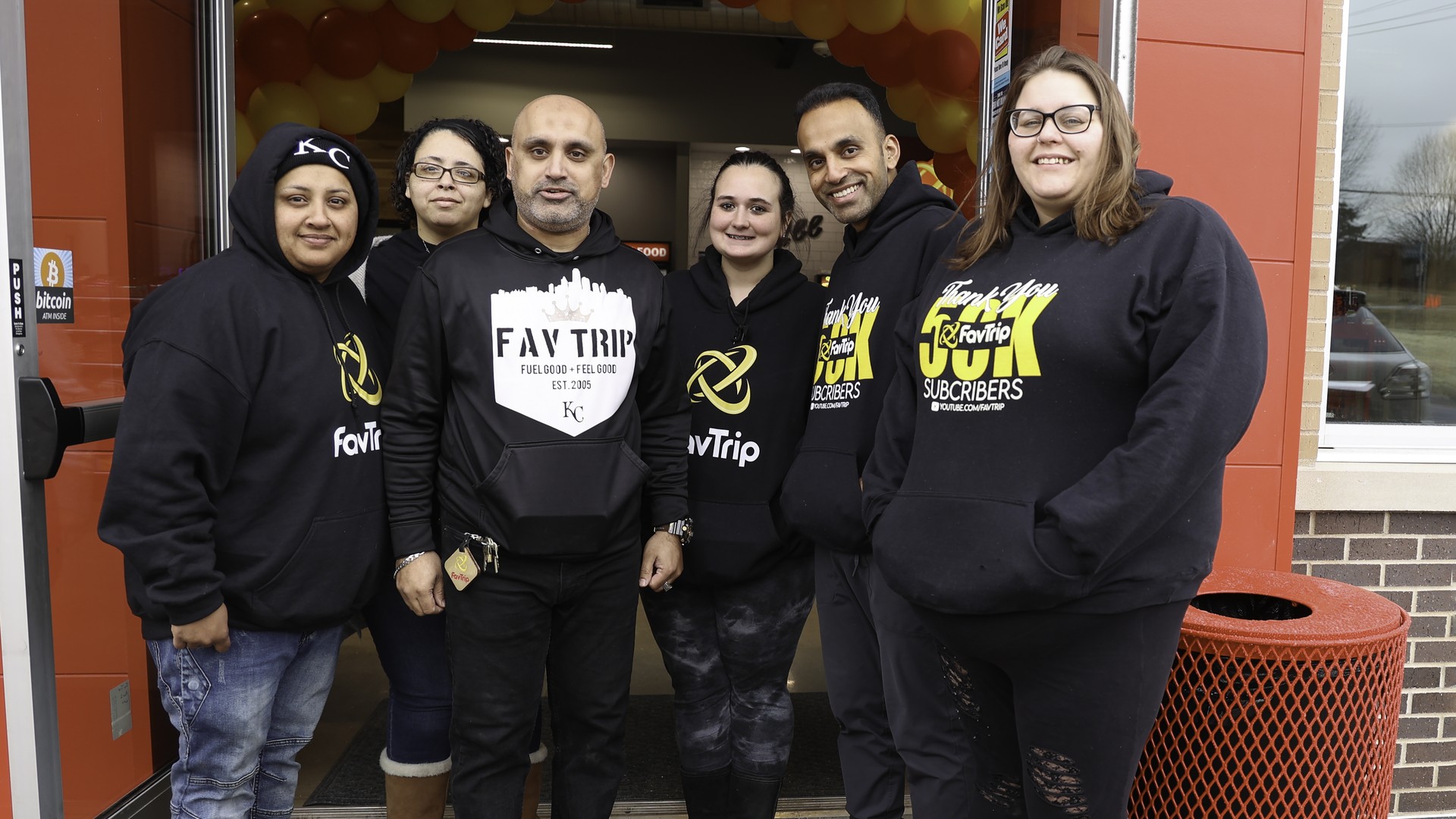 The FavTrip team in FavTrip hoodies outside the red storefront