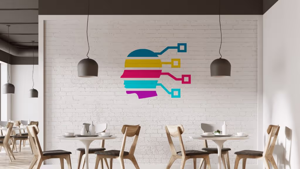 A minimalist cafe featuring light wood chairs, white brick, white tulip tables, black hanging ceiling fixtures, and a decal of The Influence Agency’s coloured logo on the brick wall.