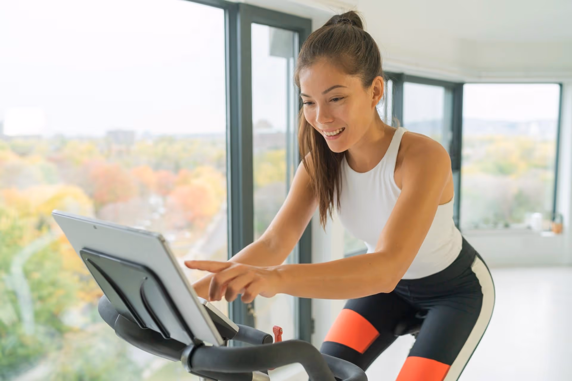 A woman riding a Peloton bike at home