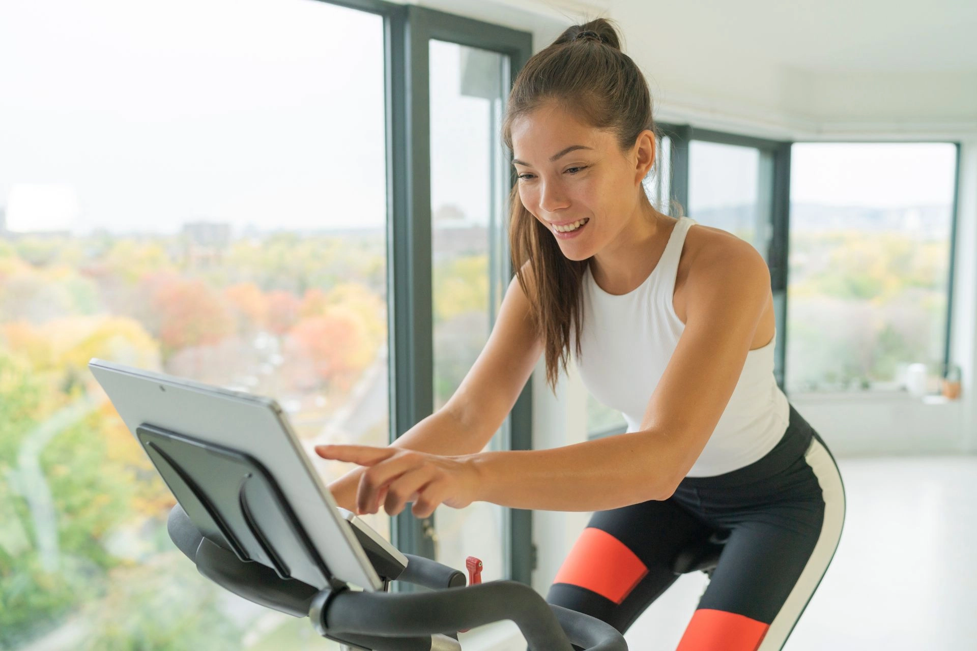 A woman riding a Peloton bike at home