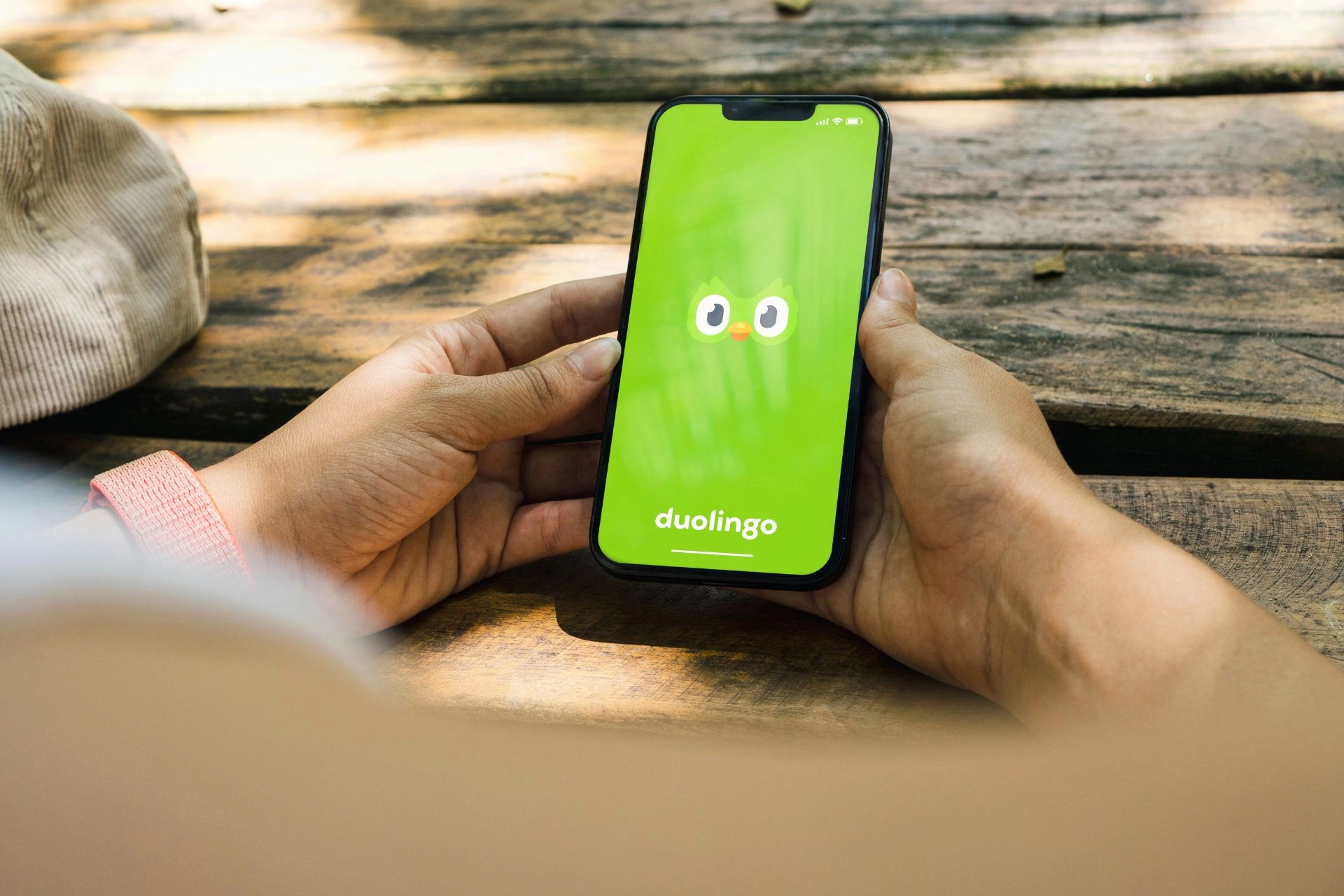 A person opening the Duolingo app on their phone