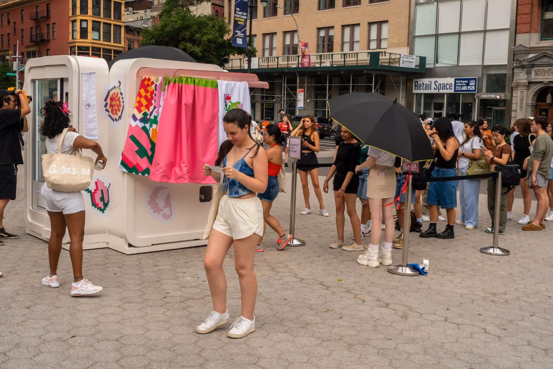 People lining up for a Glossier brand activation pop-up booth